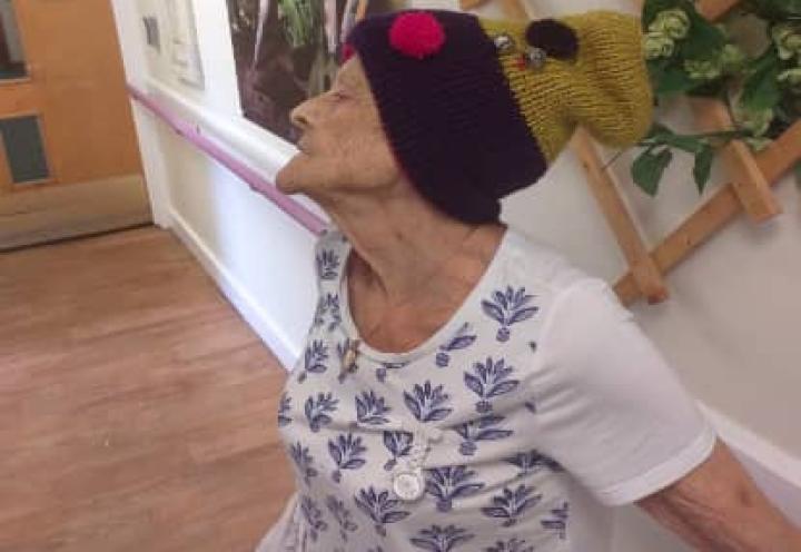 Resident modelling the hat that she knitted